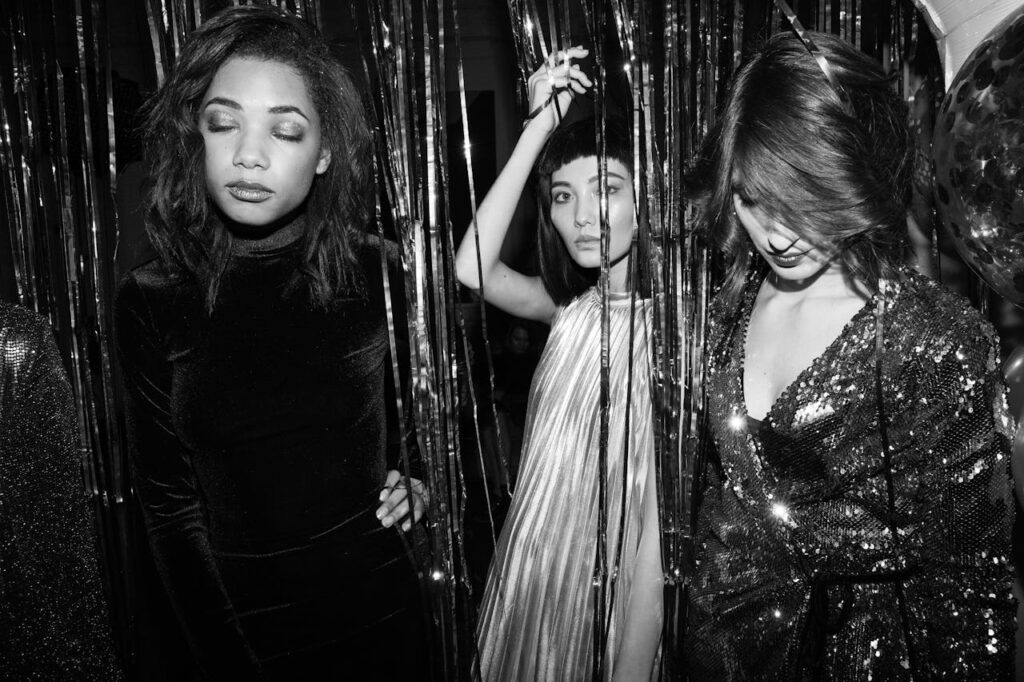 Chic monochrome photo of young women celebrating at a stylish party.